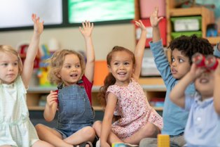 Kindergarteners raising hands.
