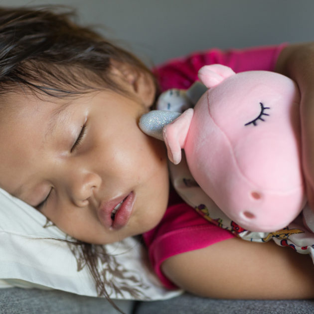 little girl sleeping with stuffed animal.